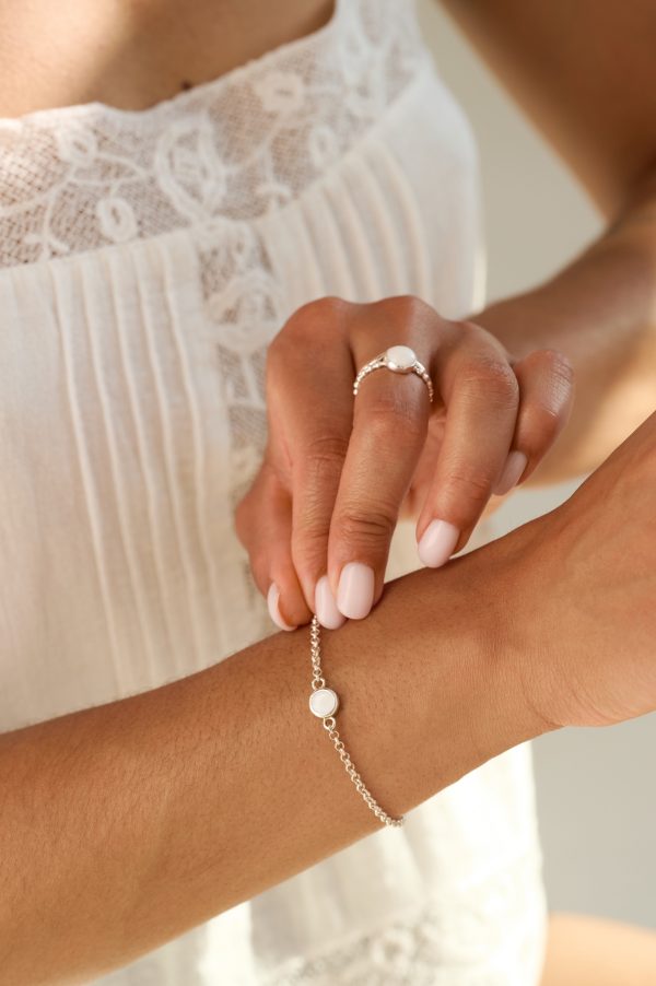 Model wearing the Celeste Mini Breastmilk Bracelet with dainty breastmilk stone set in a belcher chain, shown in a close-up for breastmilk jewellery.