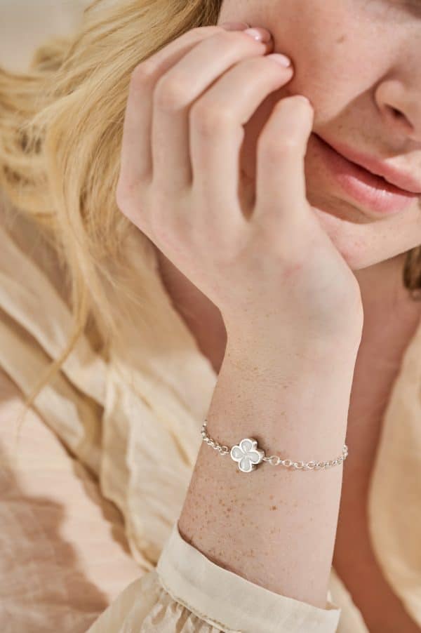 Model wearing Clover Breastmilk Bracelet – handmade breastmilk jewellery keepsake with four-leaf clover charm.